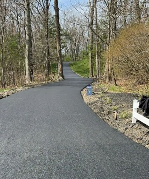 A white bench sitting on the side of a road