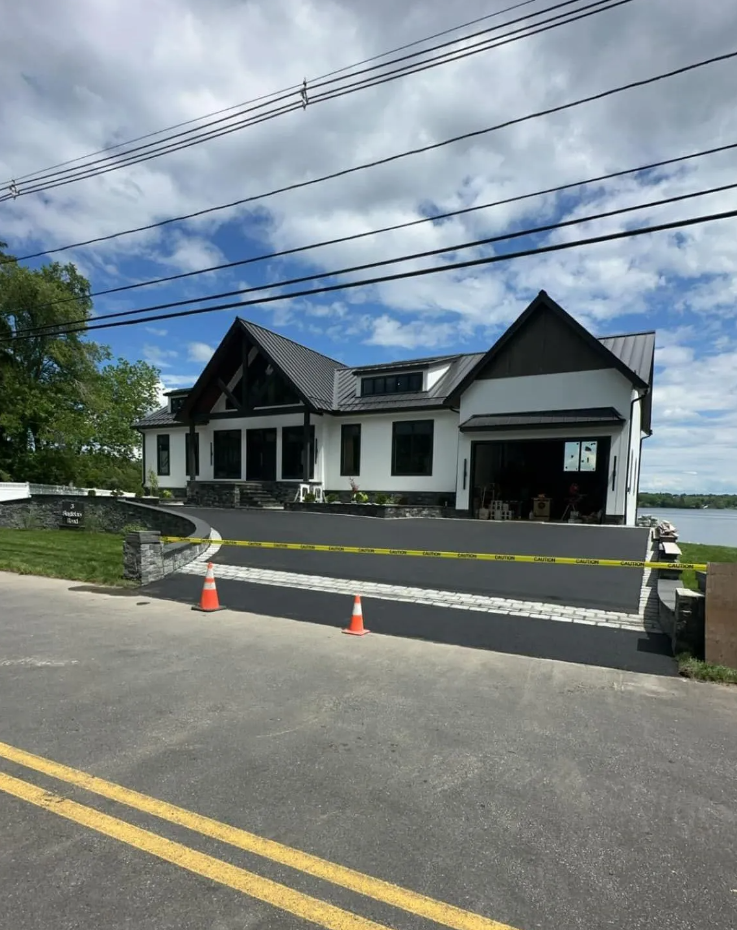 A house on the side of a road near a body of water